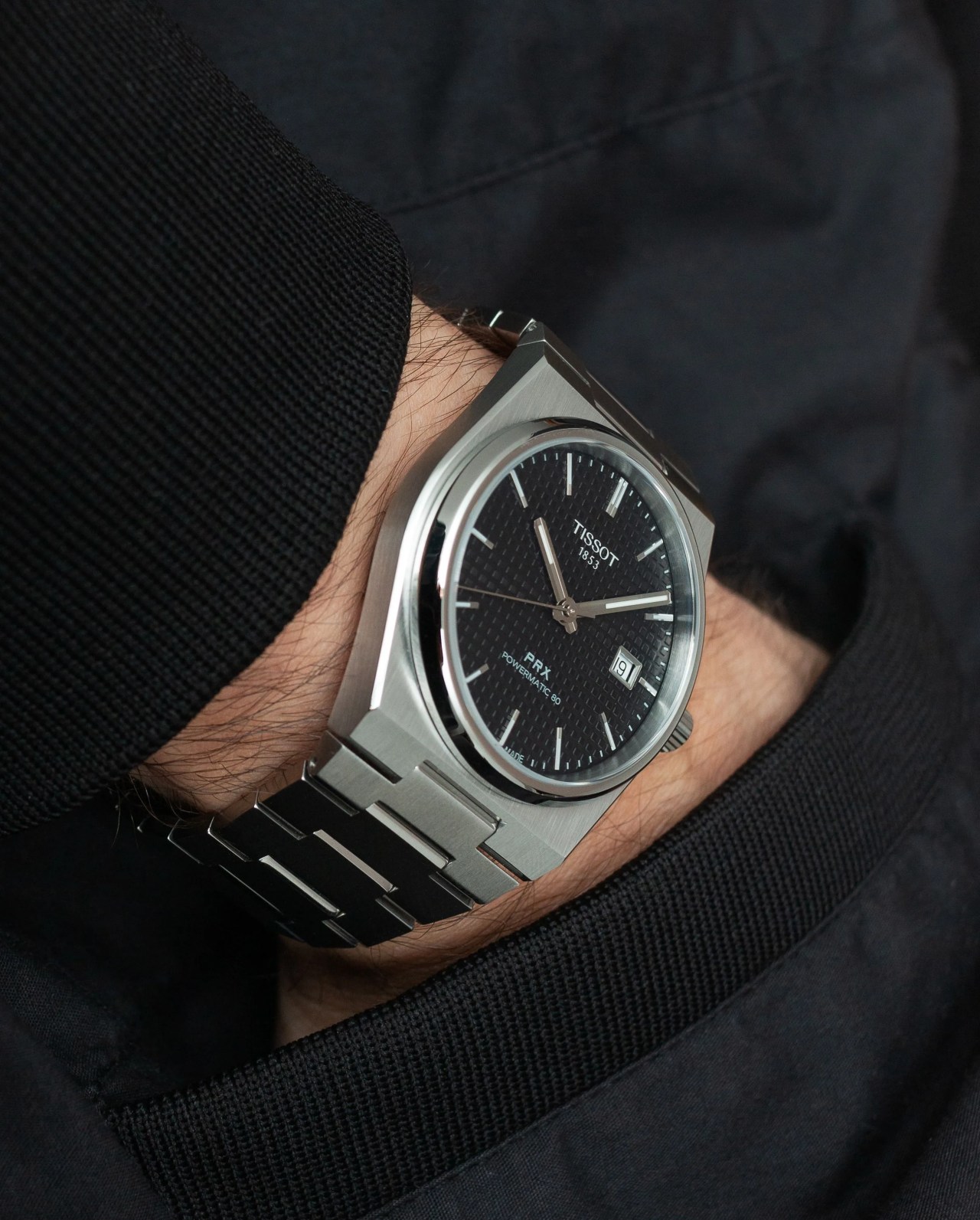 tissot prx watch worn on wrist with hand in pocket