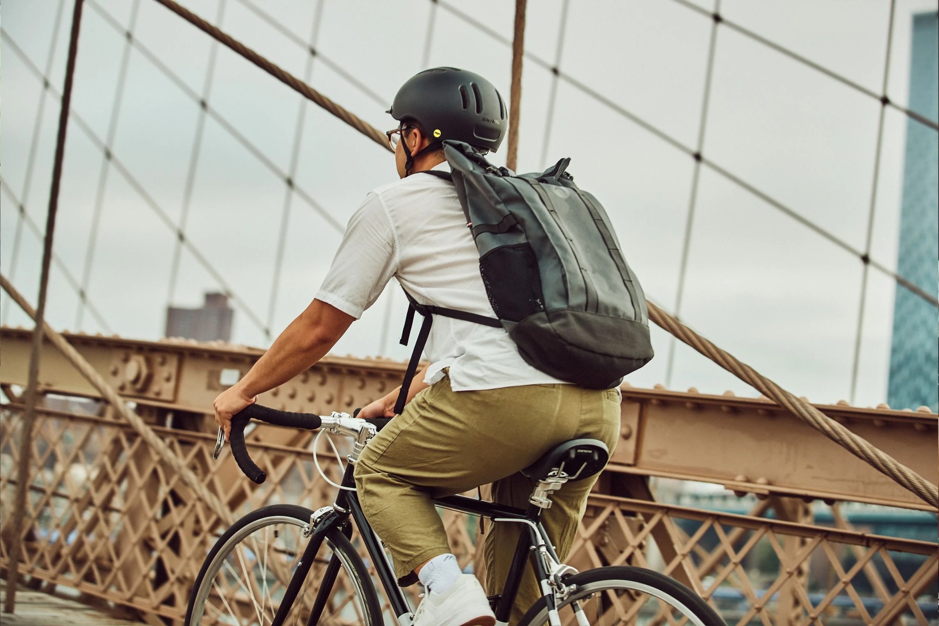 man wearing thousand helmet riding on brooklyn bridge