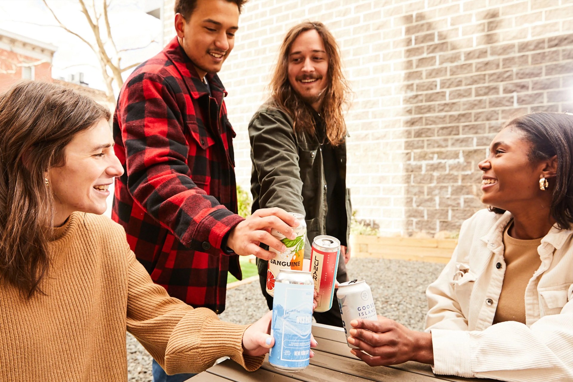 group of people clinking their beer cans together