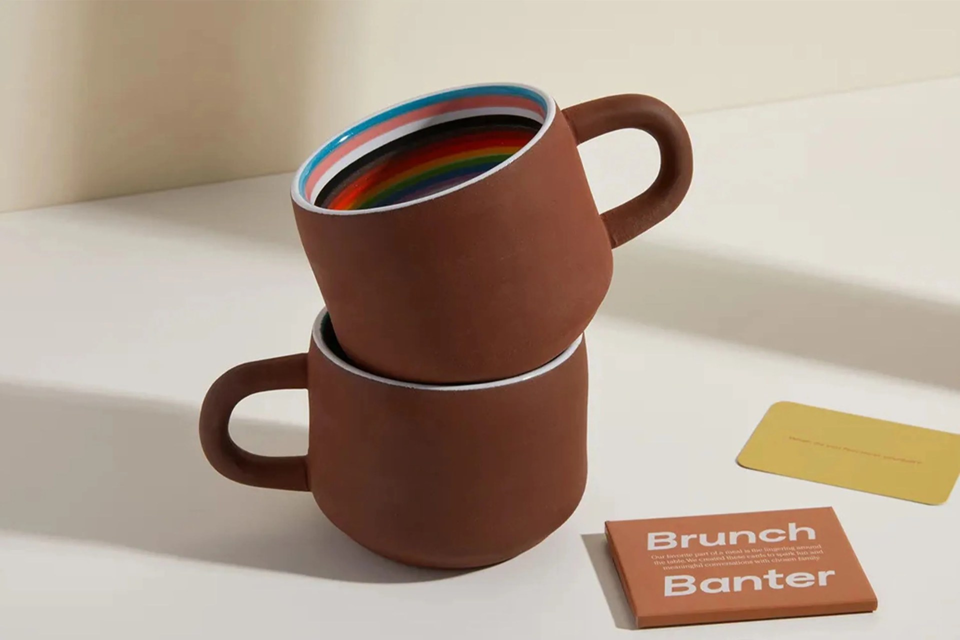 our place full of pride mugs with rainbow stripes on the inside