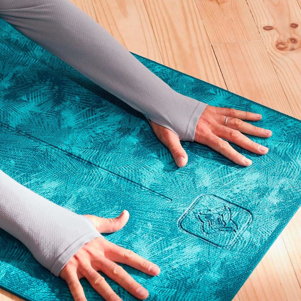 a person stretching on a blue yoga mat