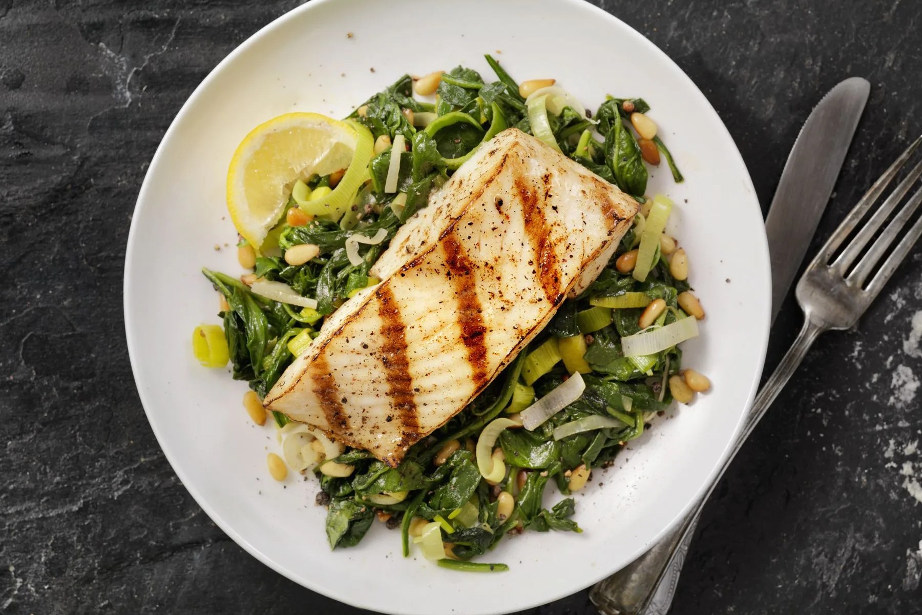 grilled halibut with spinach, leeks and pine nuts