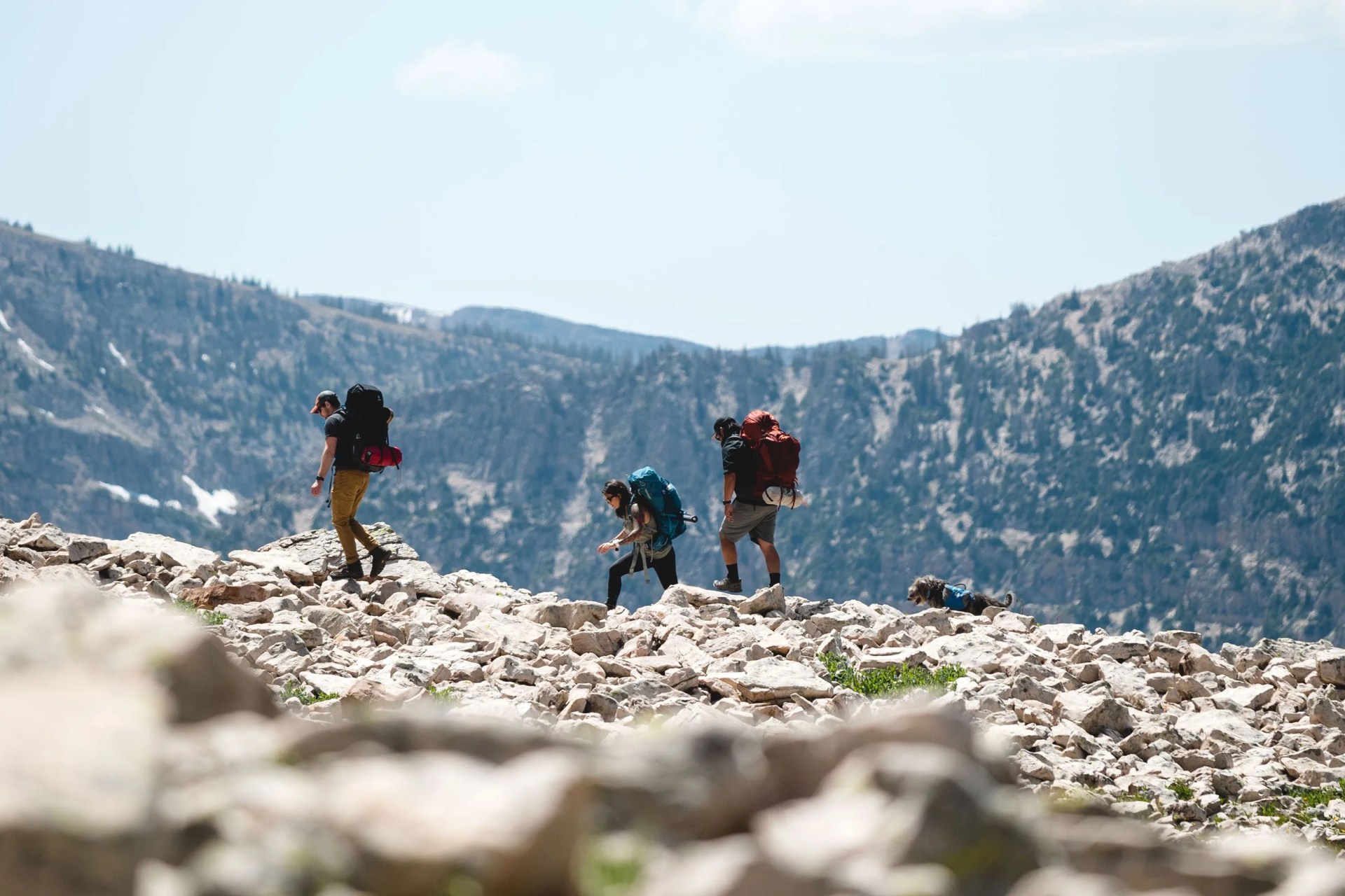 three people hiking on rocky terrain