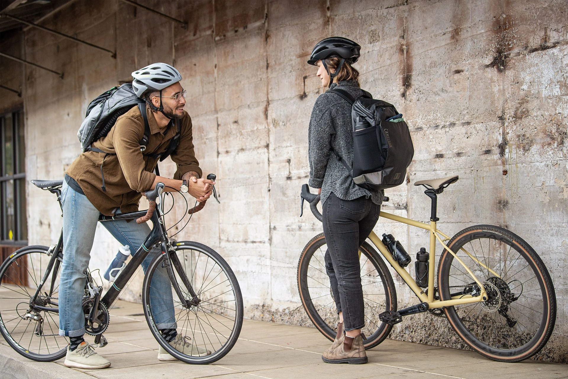 man and woman wearing camelbak commuter packs