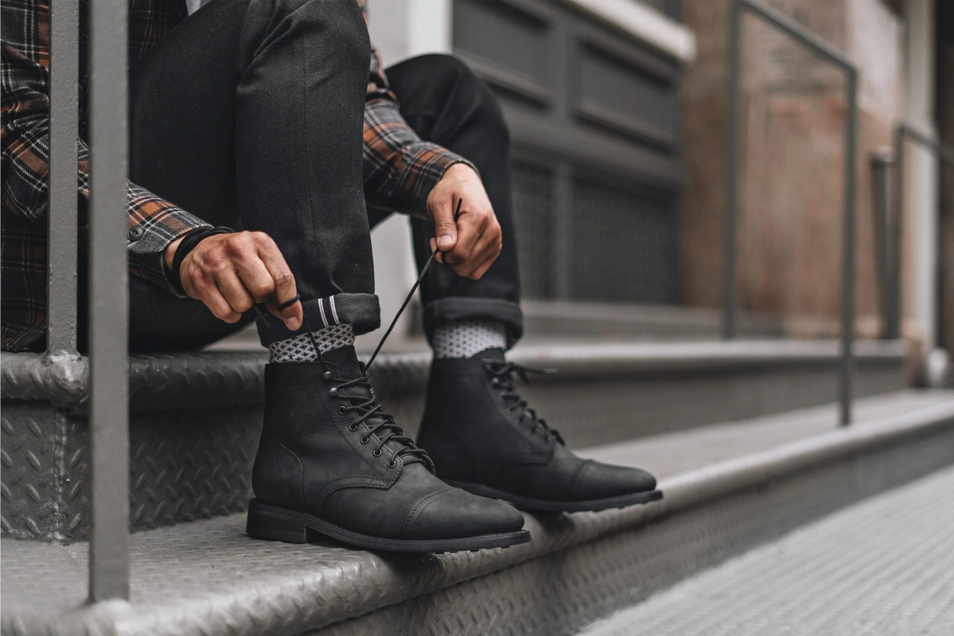 man lacing up thursday boot co boot