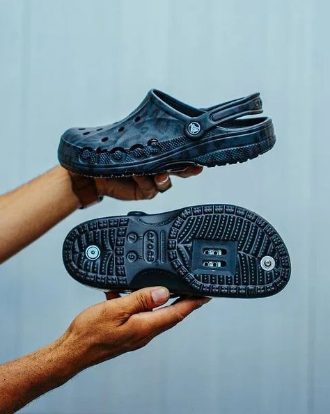 hands holding blue crocs