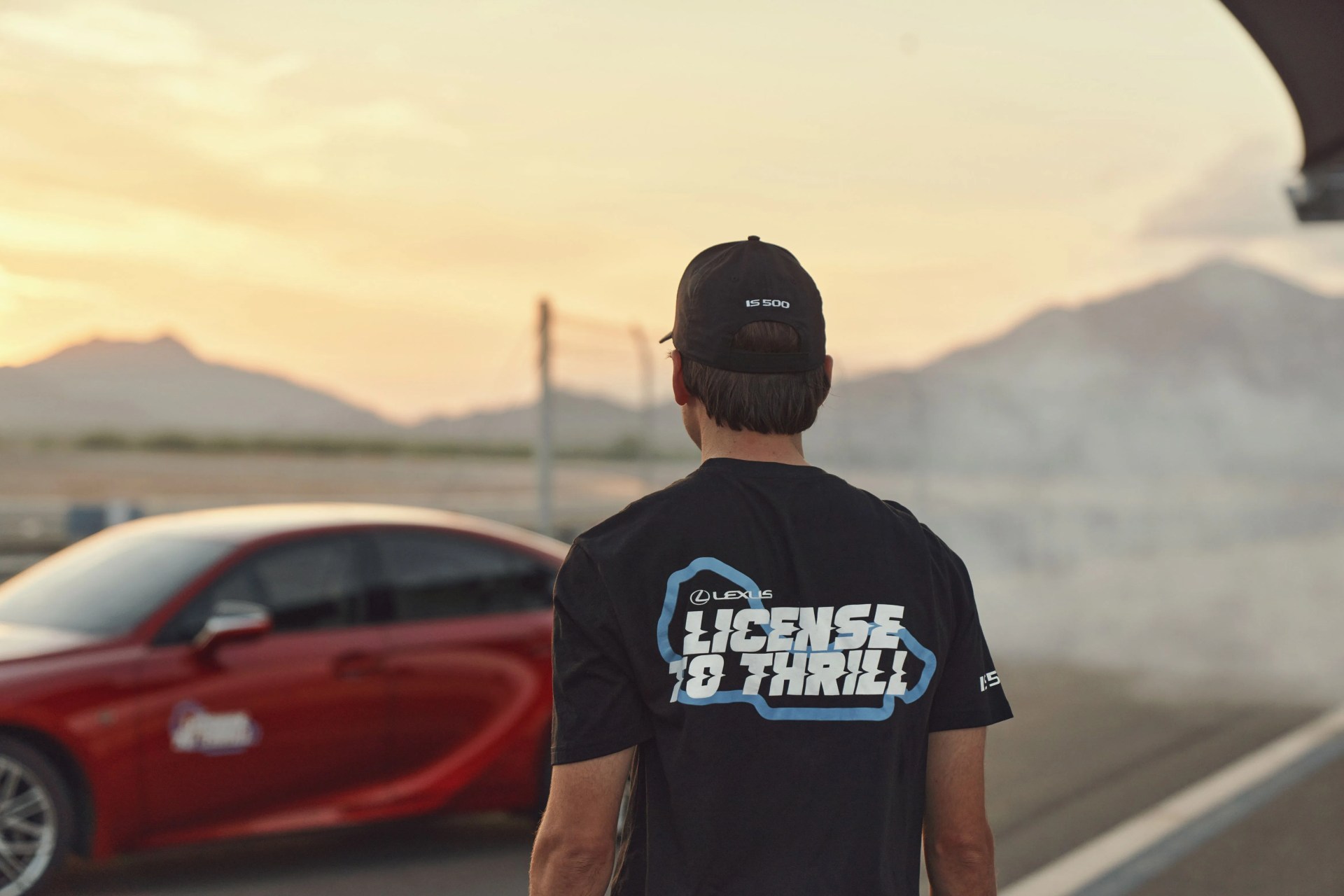 man walking towards red lexus car