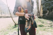 mid section of female boulderer holding climbing shoes, lombardy, italy