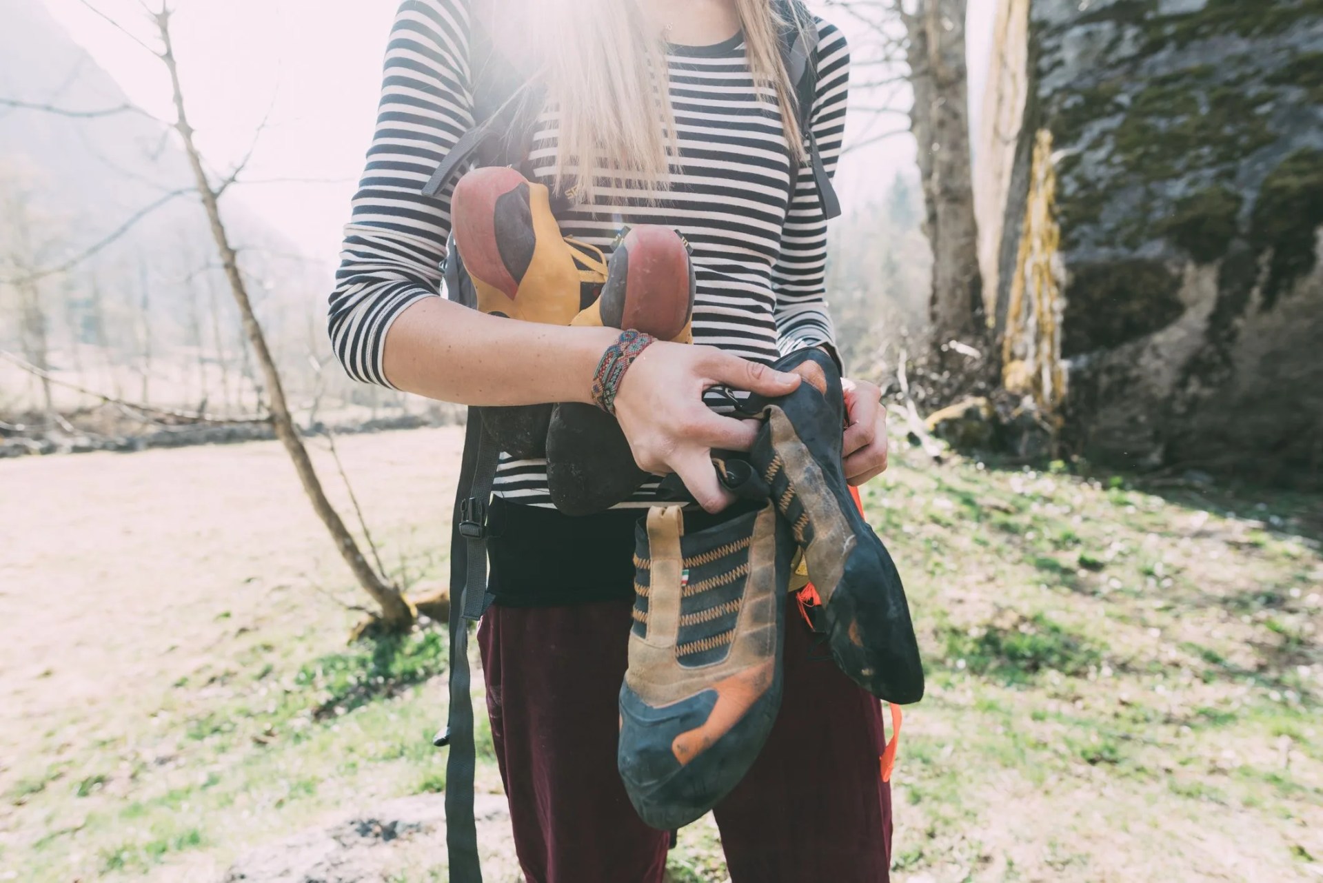 mid section of female boulderer holding climbing shoes, lombardy, italy