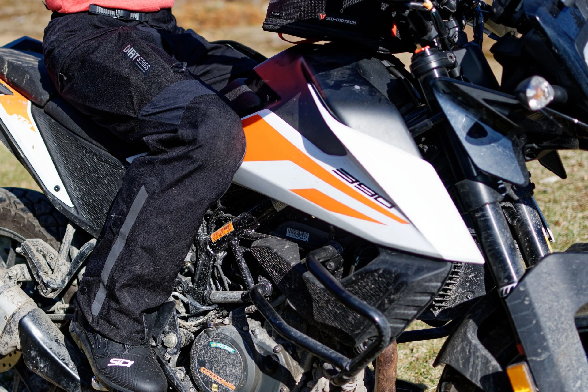 a person sitting on a motorcycle wearing pants