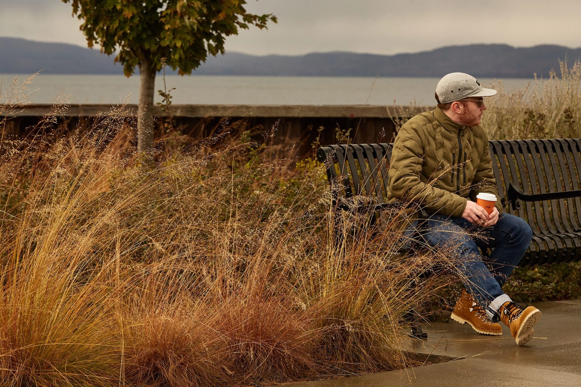 man wearing aether jacket sitting on bench