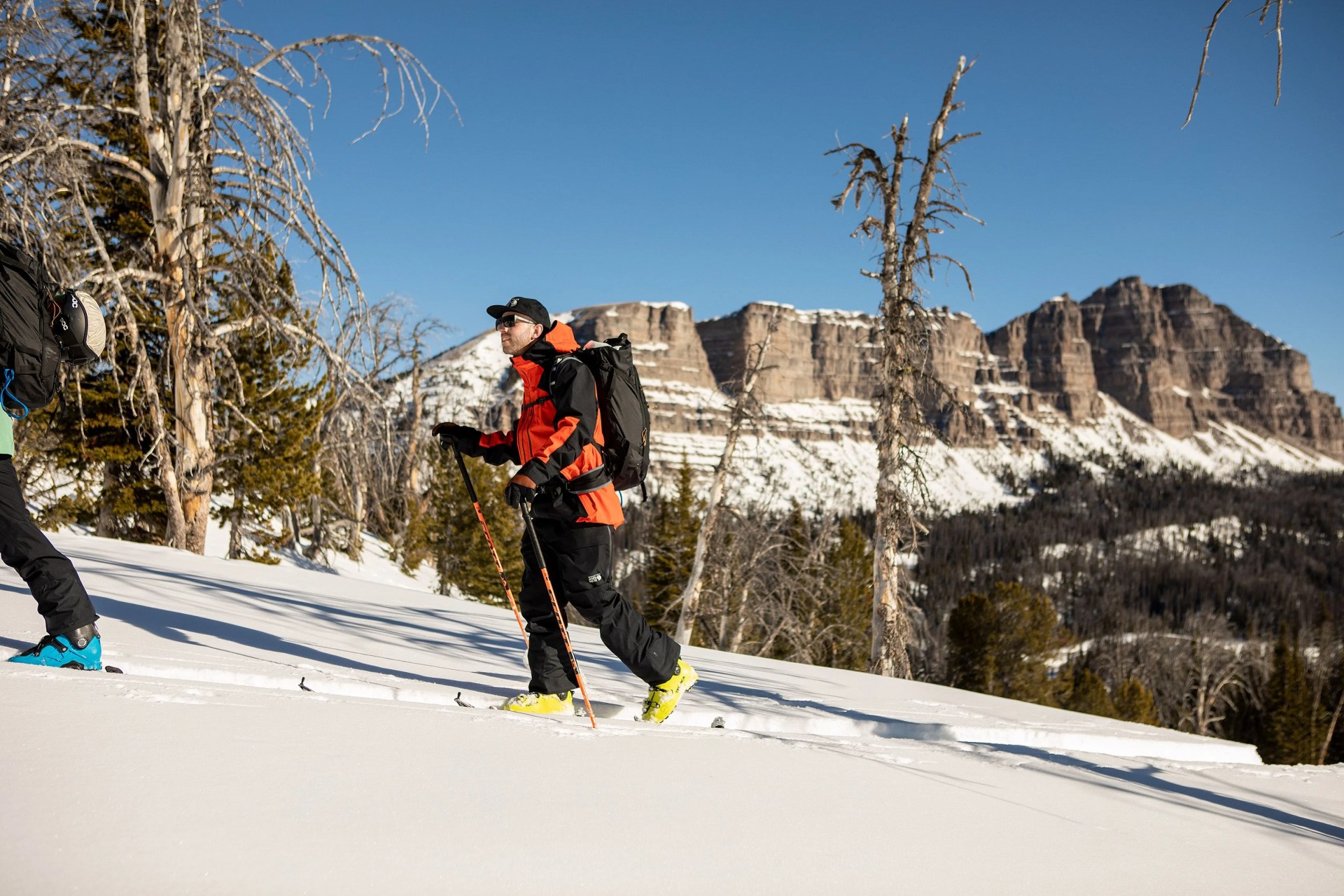 man walking up snowy mountain wearing mountain hardware gear