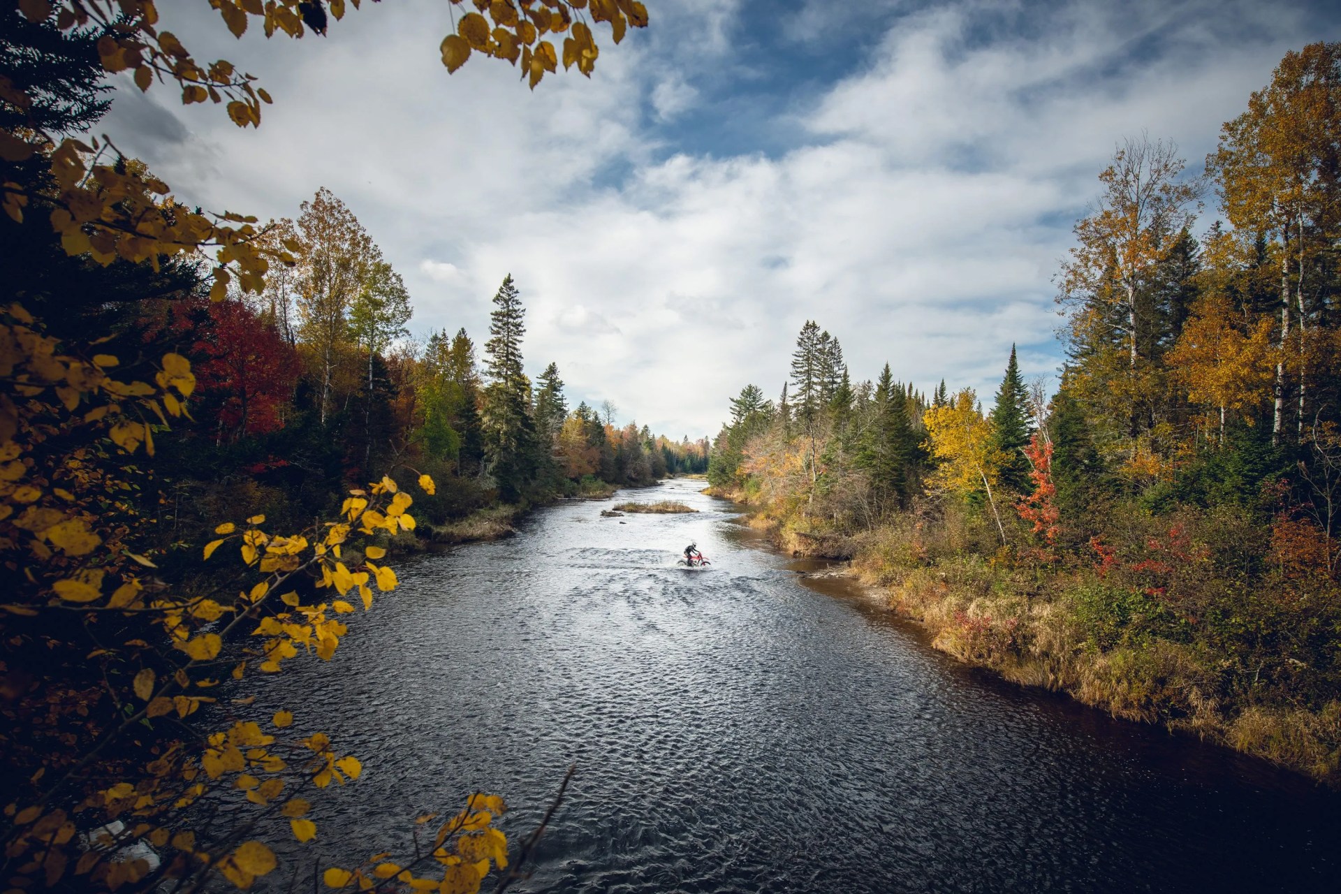 person riding across a river wearing fox racing gear