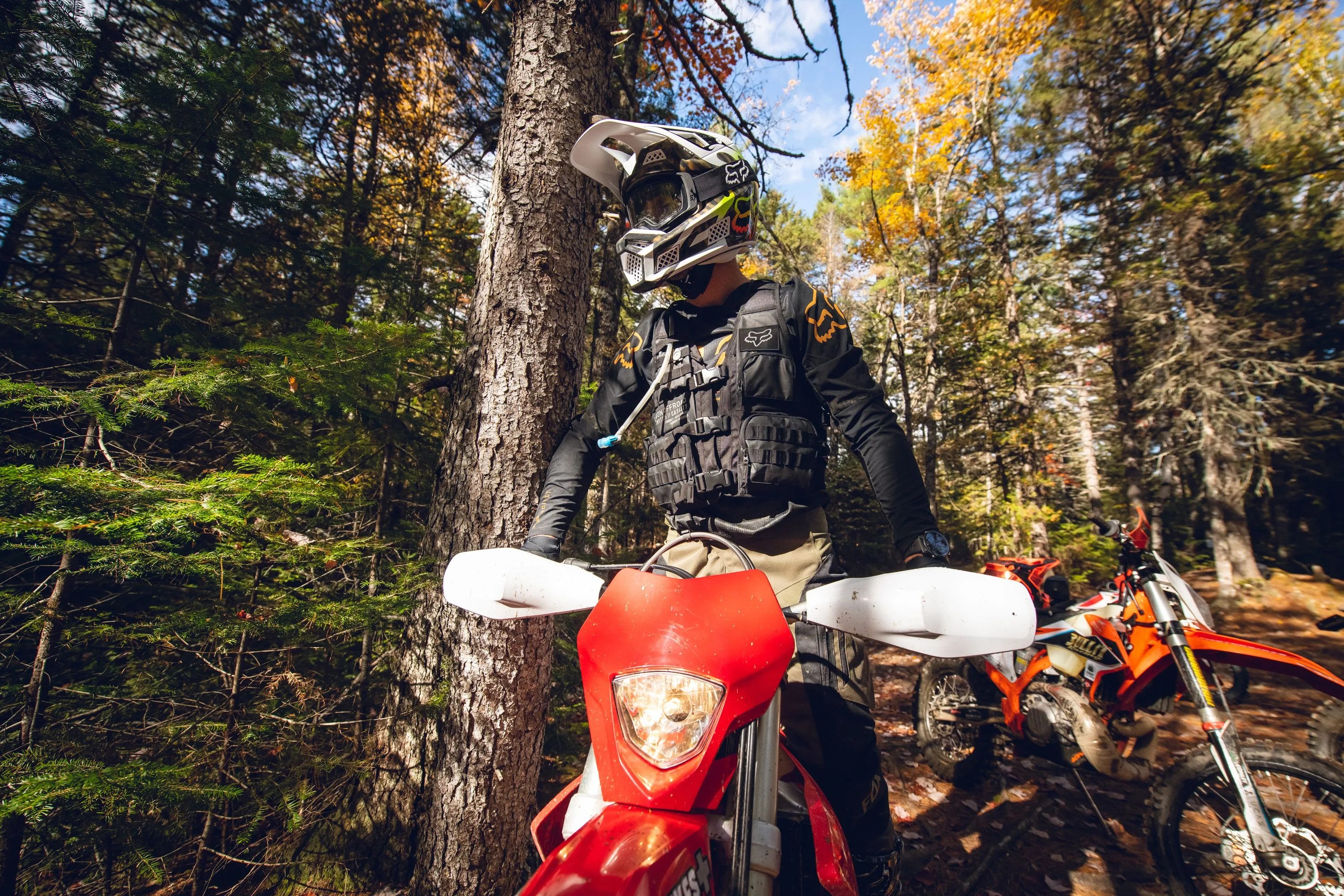 person resting on motorcycle wearing fox racing gear