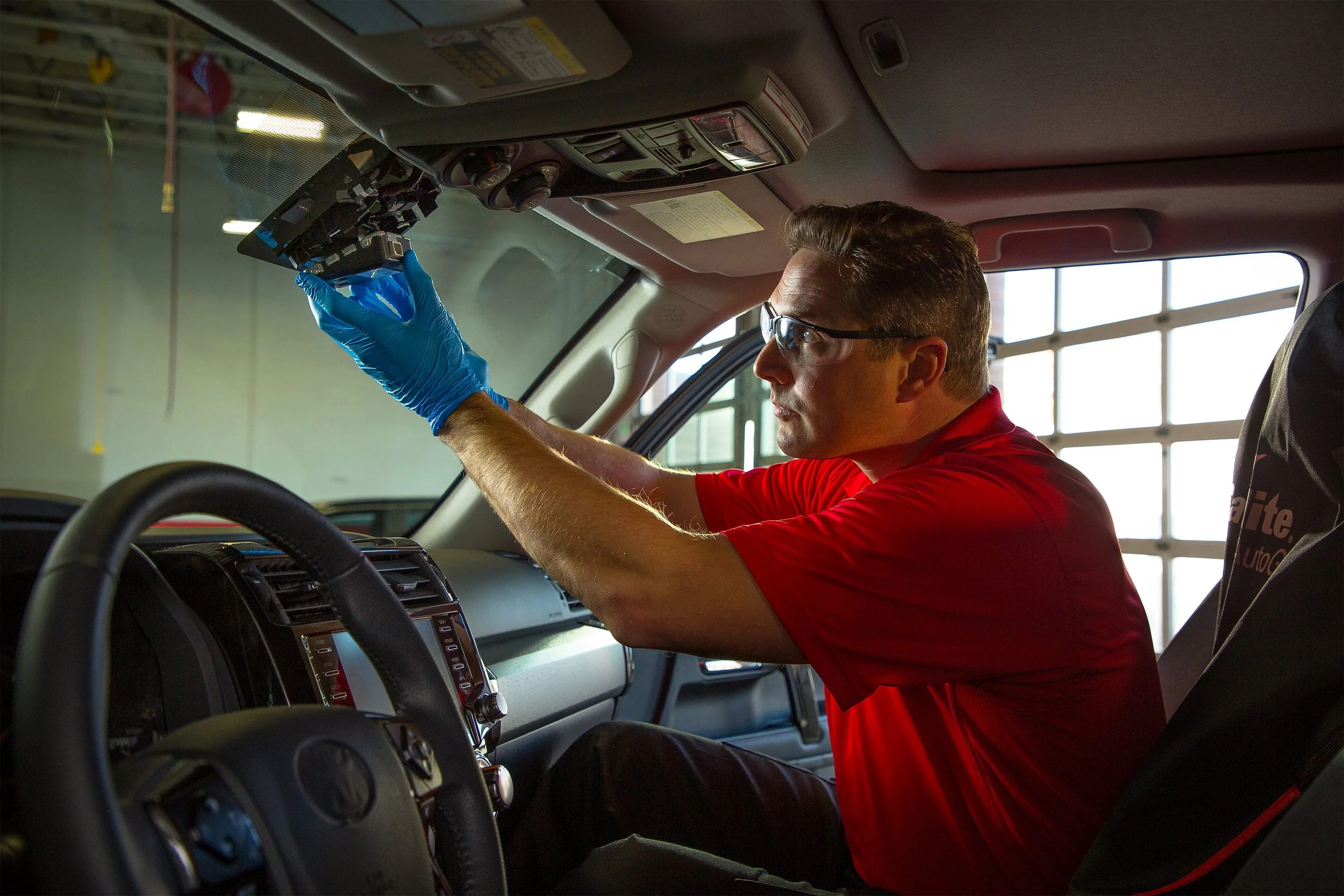 man swapping out light in car