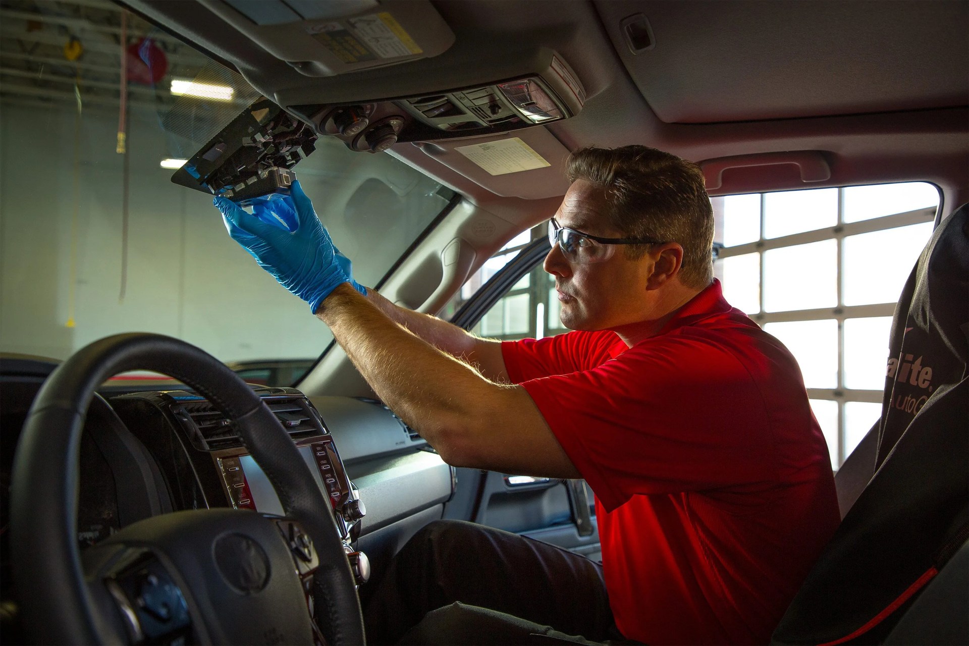 man swapping out light in car
