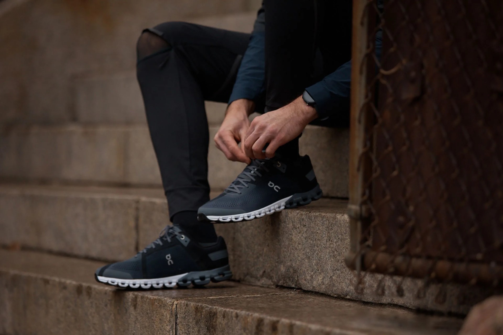 person tying their on running cloud shoes