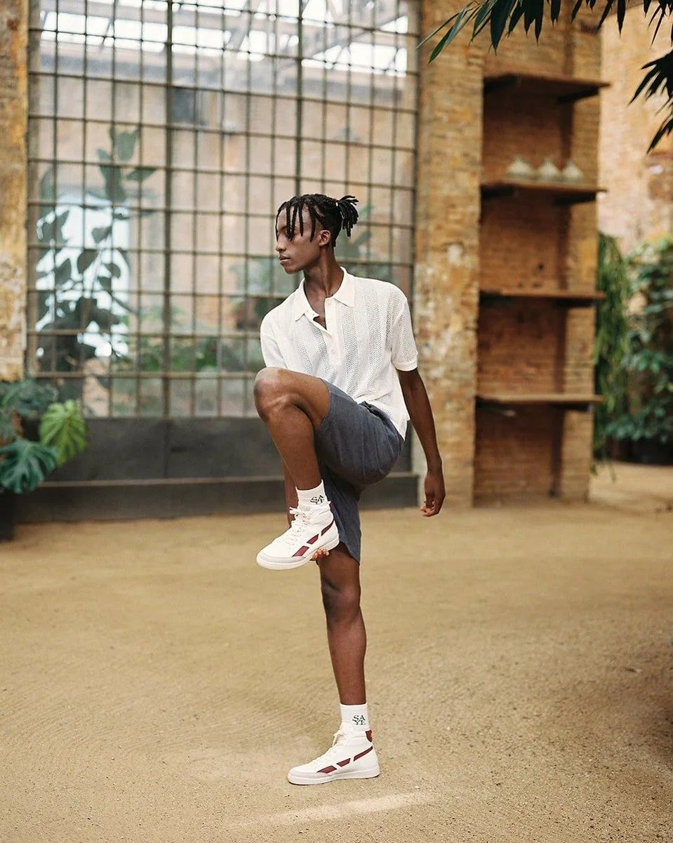 man stretching wearing saye high top garnet sneakers