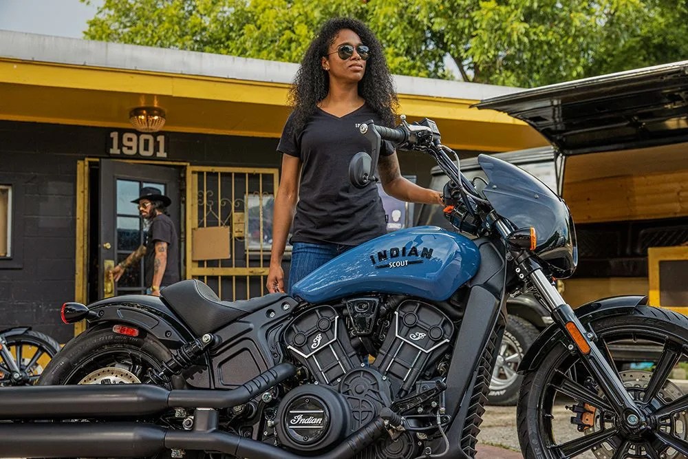 woman standing with indian motorcycle scout rogue
