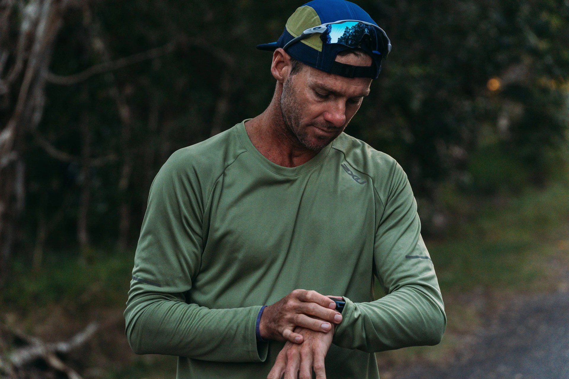 man wearing 2xu gear looking at his watch