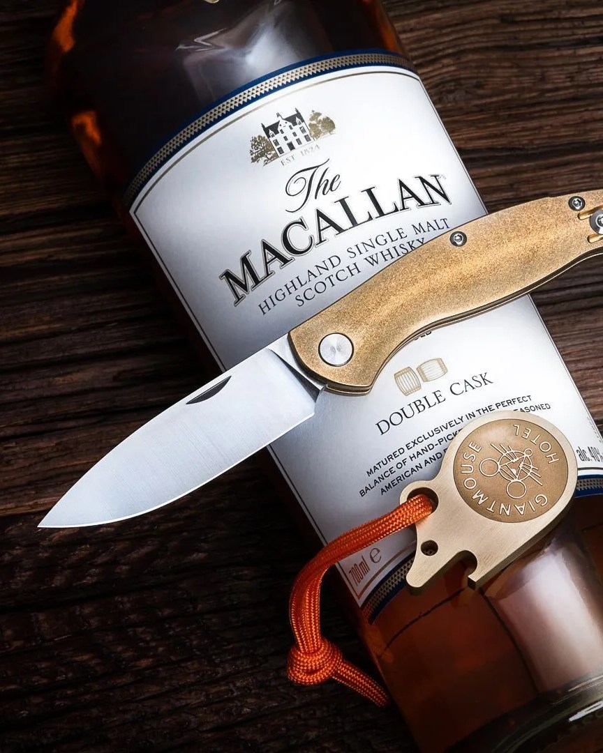 giantmouse ace falrye slipjoint brass knife on top of the macallan highland single malt scotch whisky