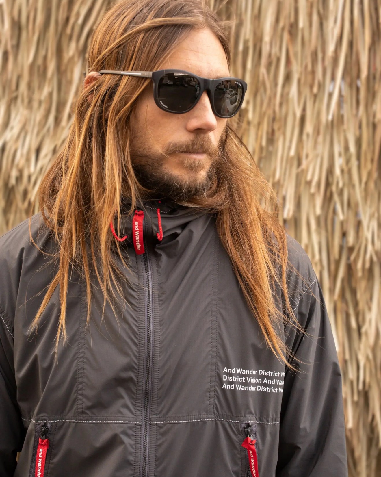 man wearing district vision nako multisport sunglasses and wander pertex wind jacket