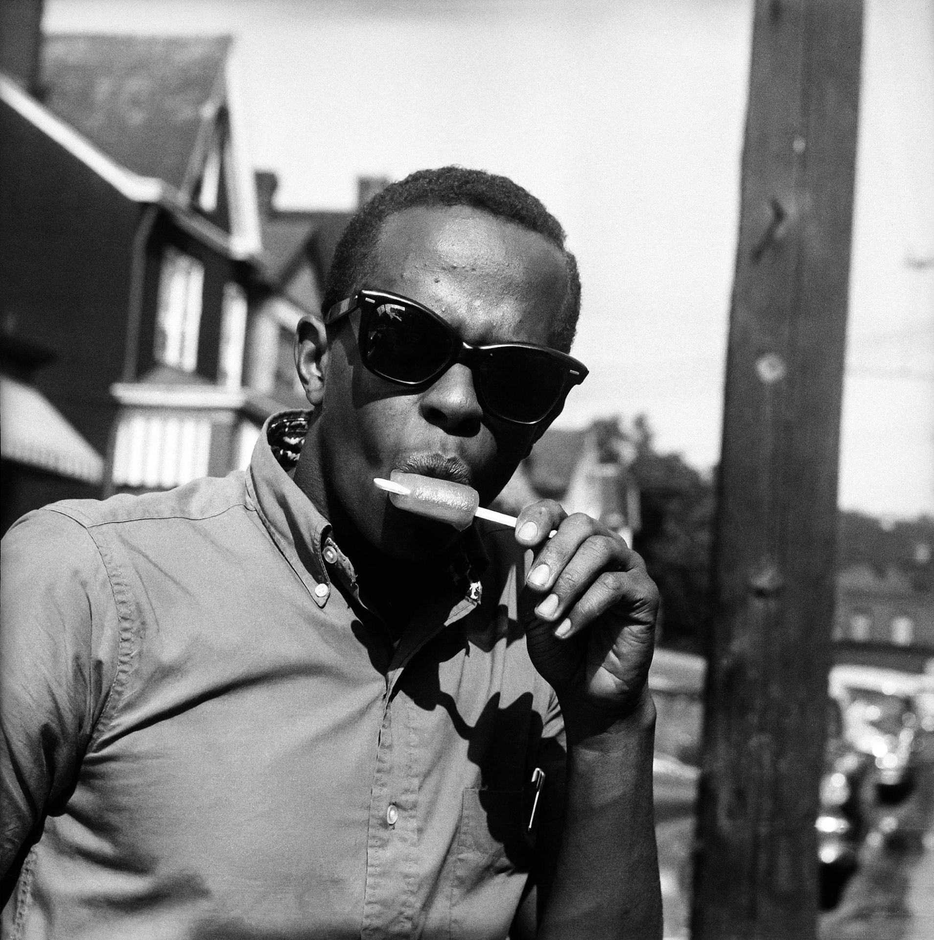 man wearing sunglasses and eating popsicle, standing in front of telephone pole and houses, pittsburgh, pennsylvania, c 1960 photo by charles 'teenie' harriscarnegie museum of artgetty images