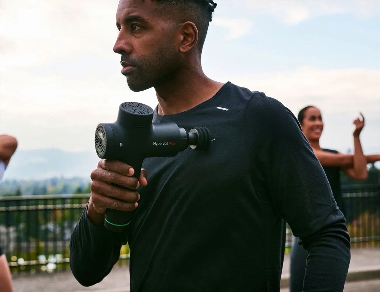 man using hypevolt massage gun on chest