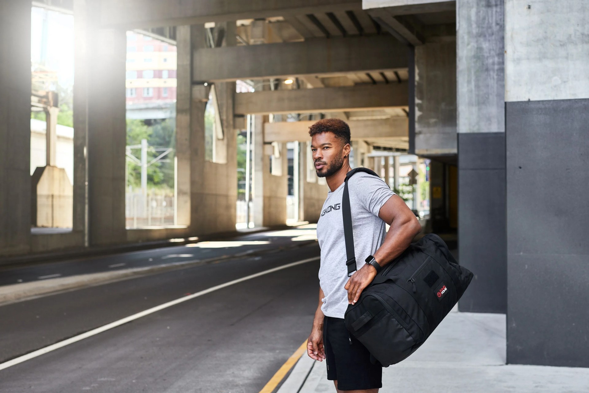 man carrying king kong apparel duffel bag
