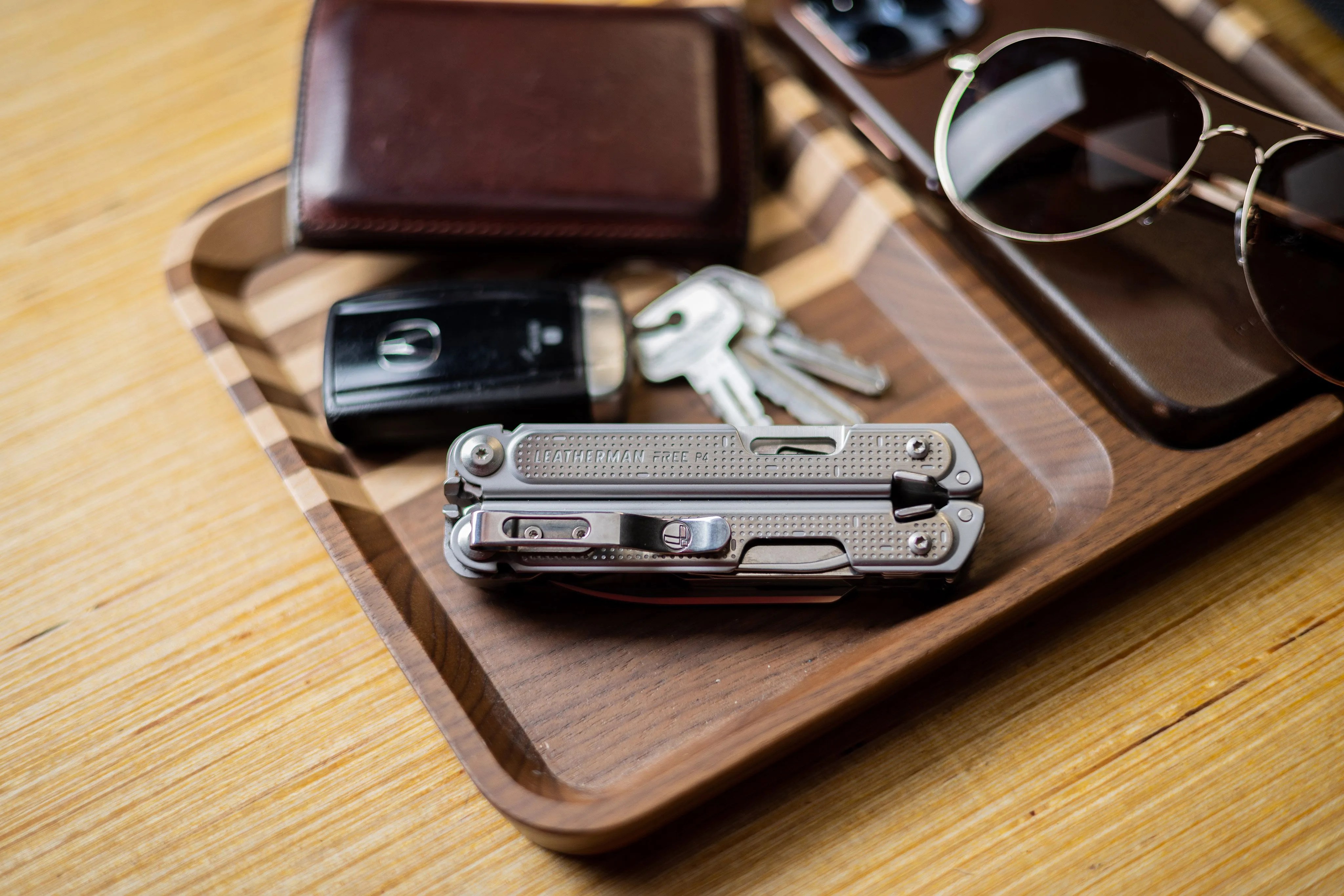 leatherman p4 multi tool next to car keys, wallet, and sunglasses