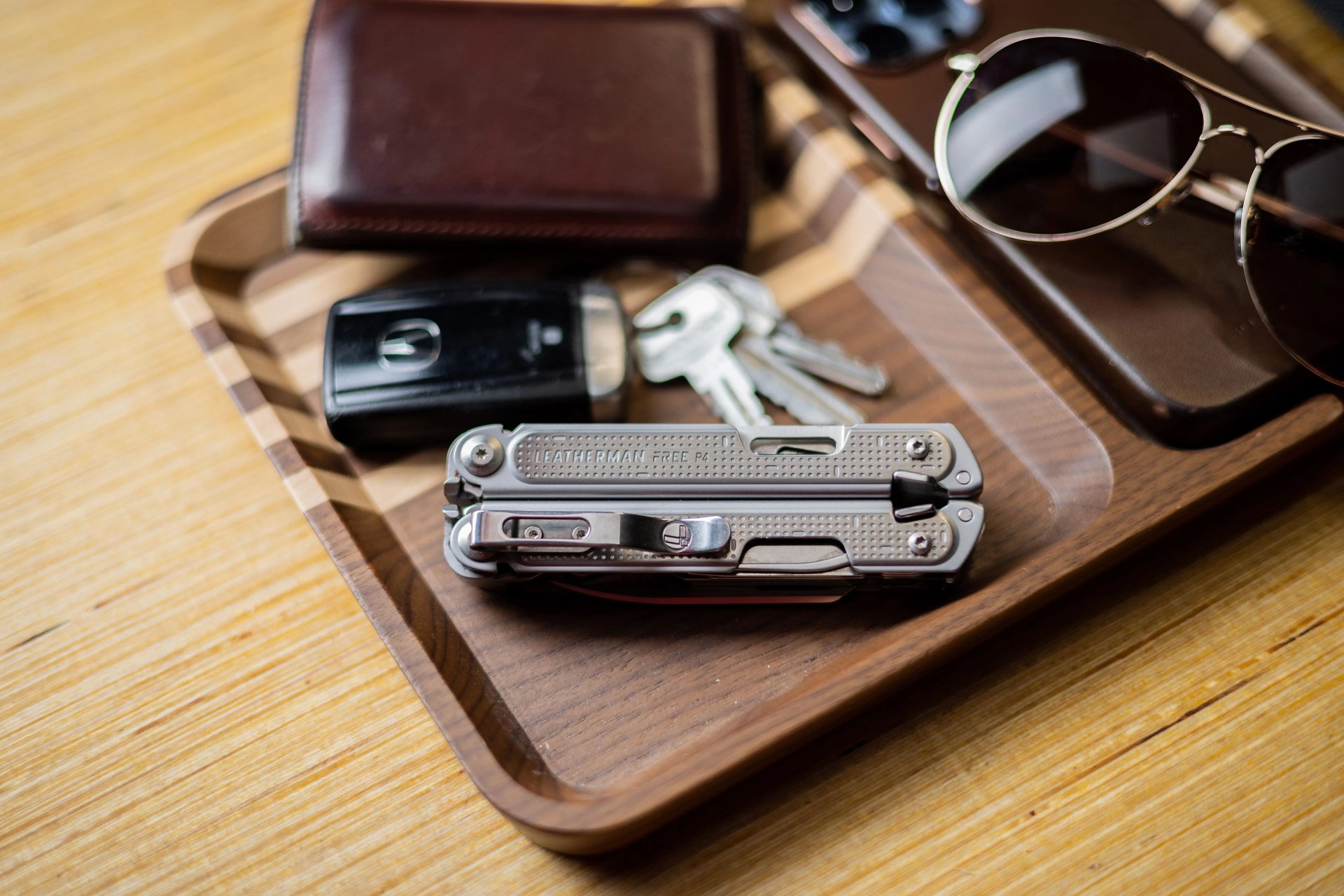leatherman p4 multi tool next to car keys, wallet, and sunglasses