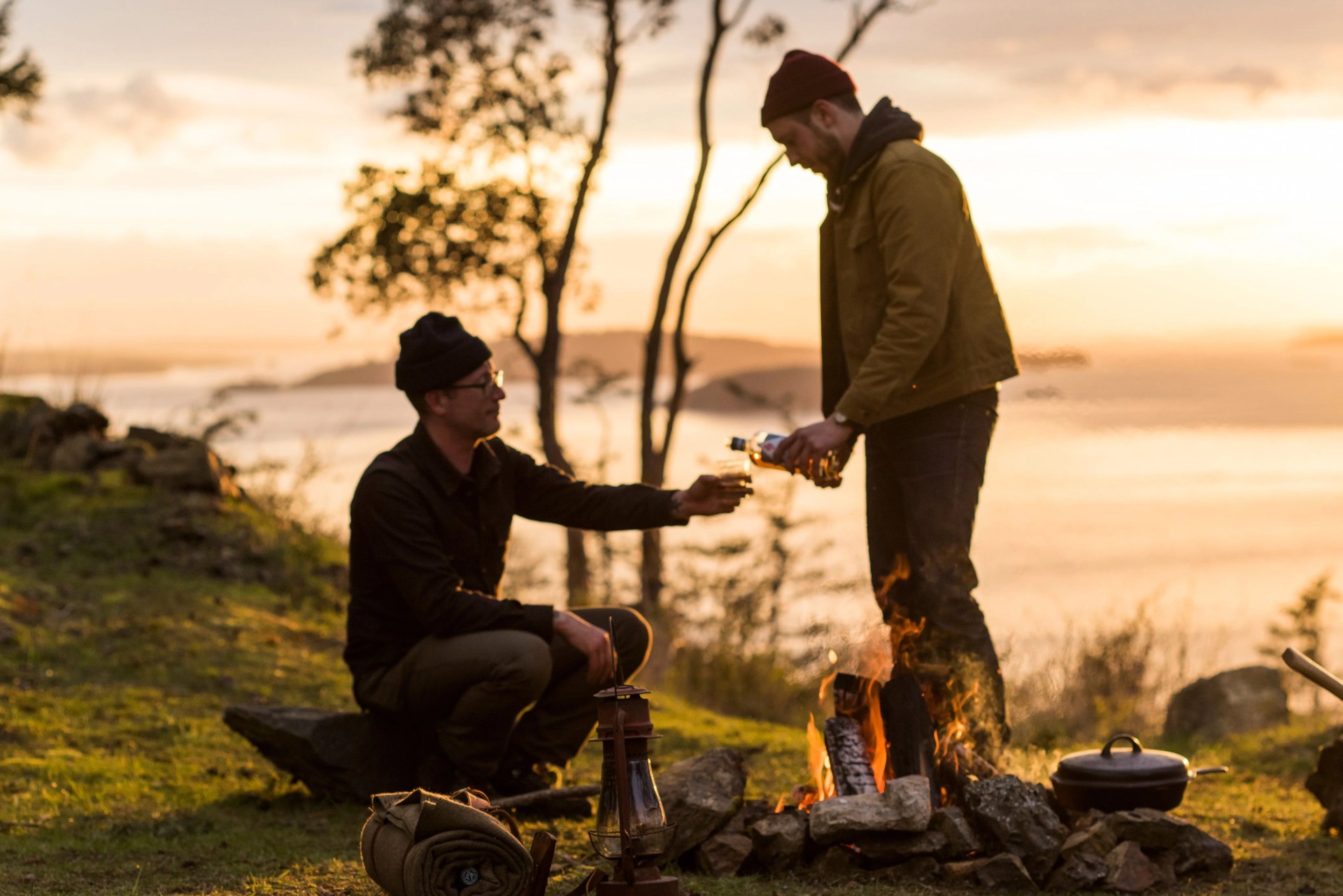 two people sherry westland whiskey at a campfire
