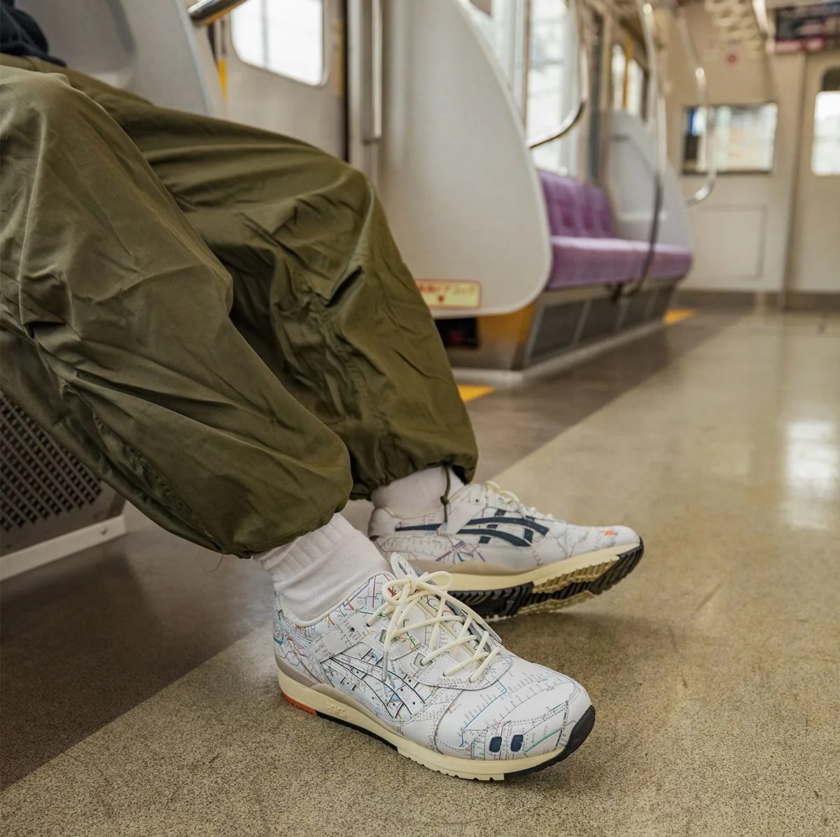 model wearing asics sneakers on the tokyo metro