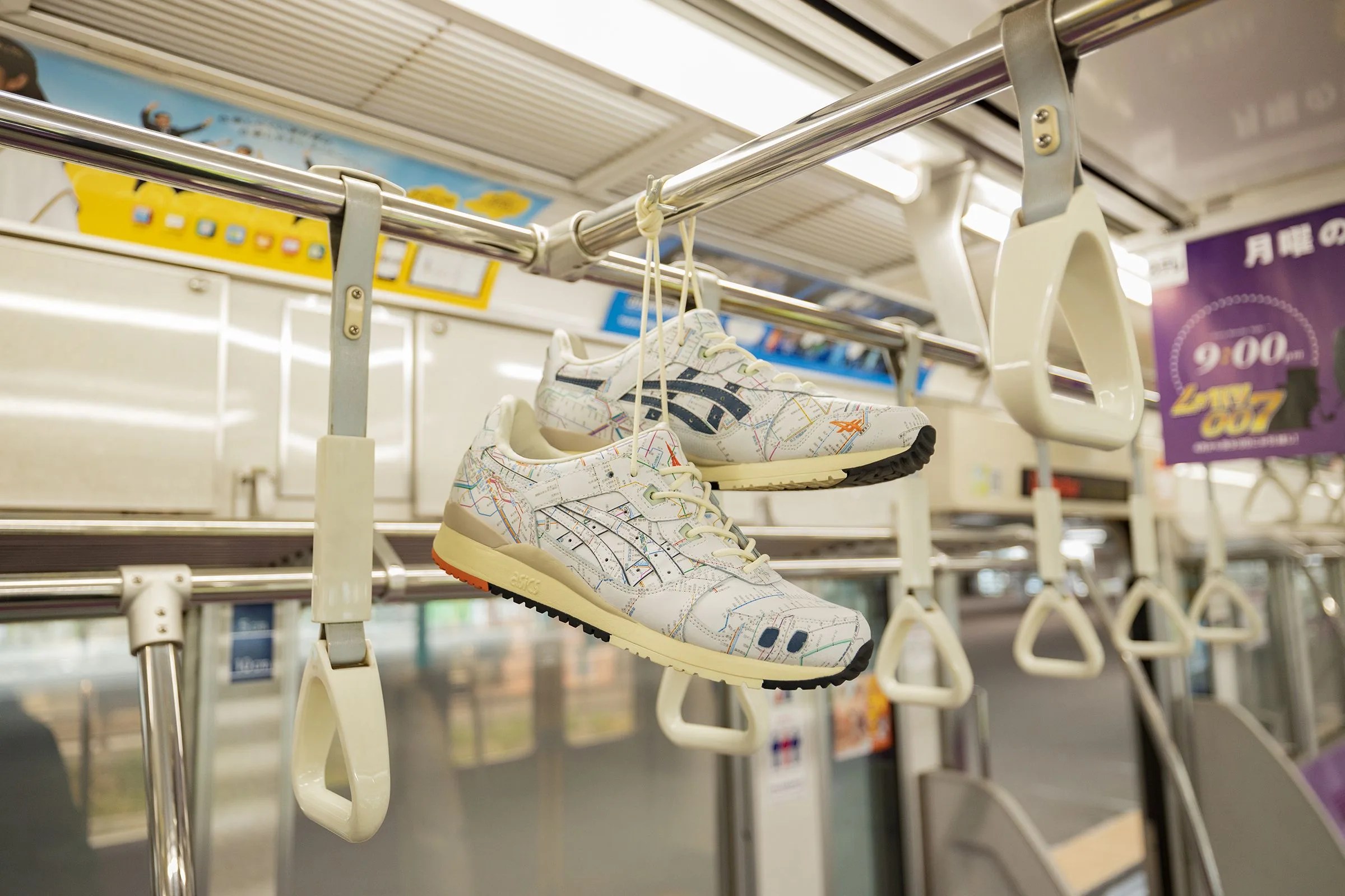 asics sneakers hanging from a rail inside a tokyo subway car