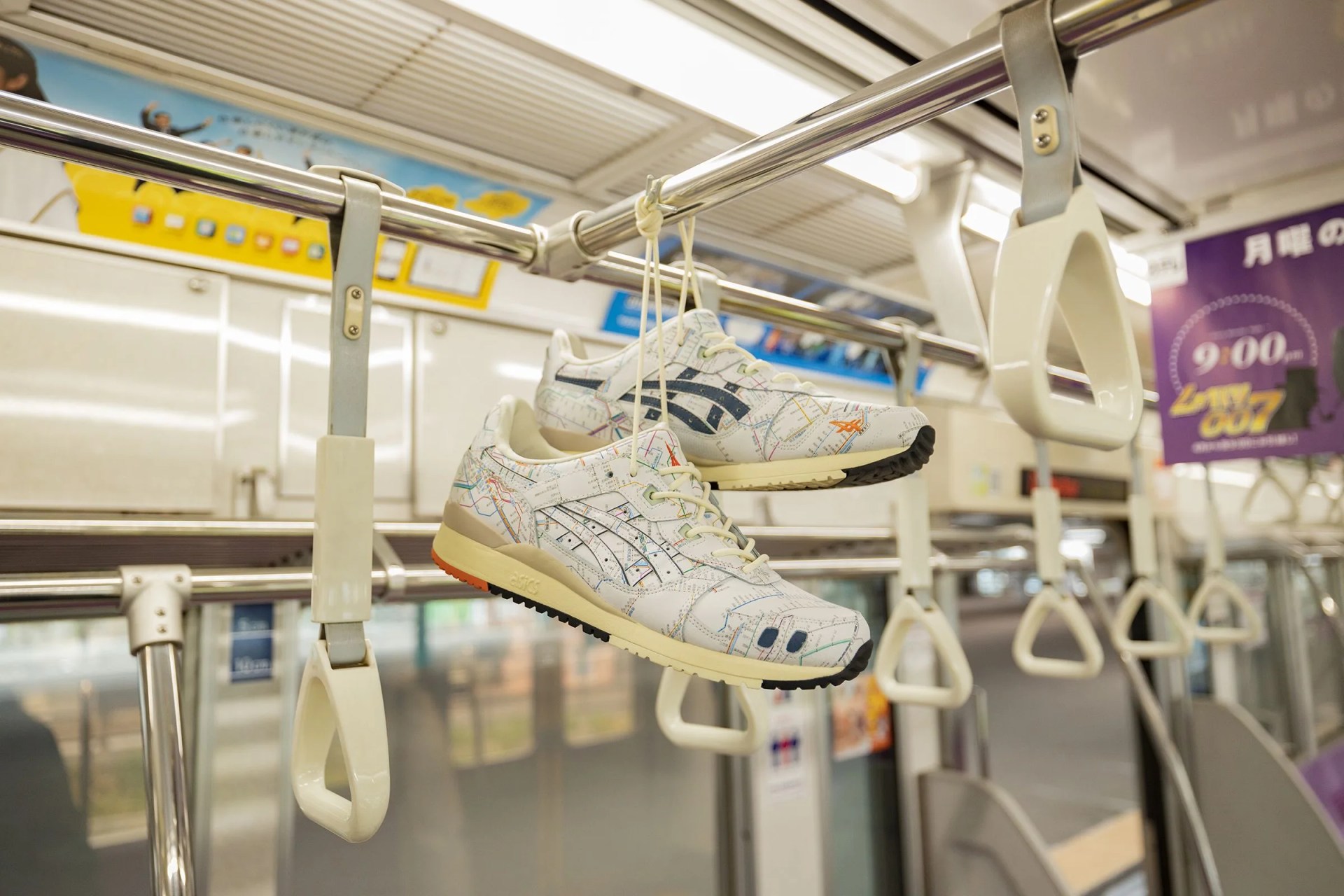 asics sneakers hanging from a rail inside a tokyo subway car