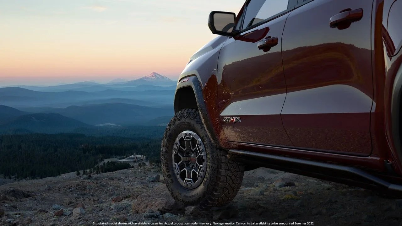 preview image showing front tire of the new gmc canyon at4x overlanding truck with a mountain off in the distance