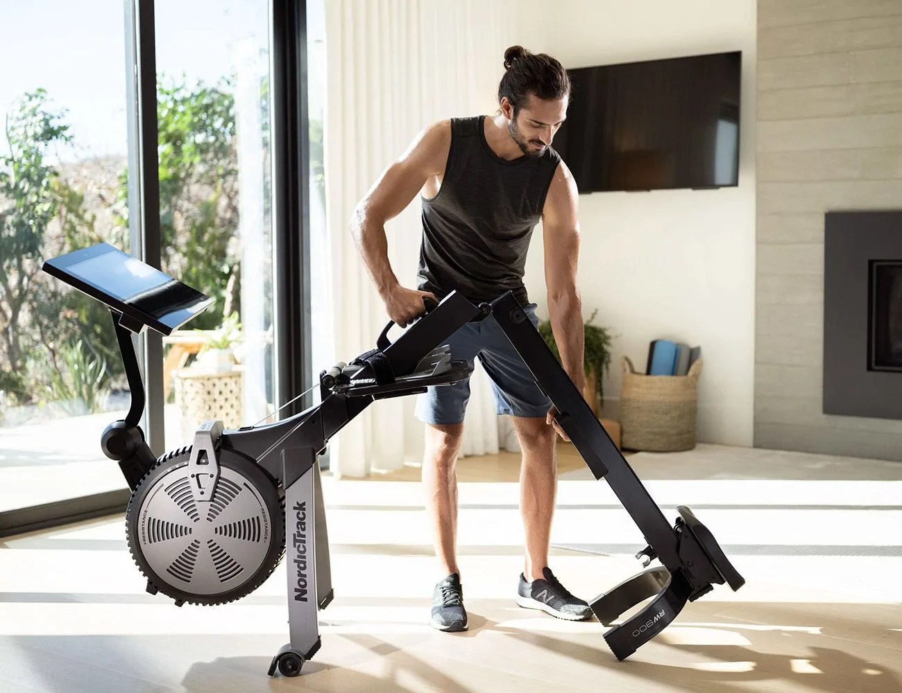man putting away nordictrack rowing machine