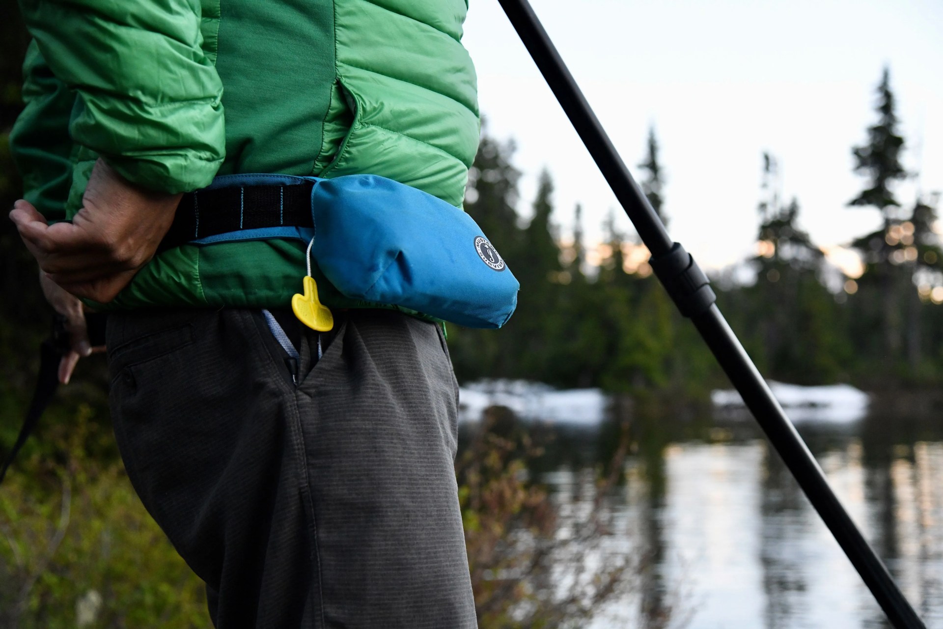 man wearing mustang survival fanny pack while paddle boarding