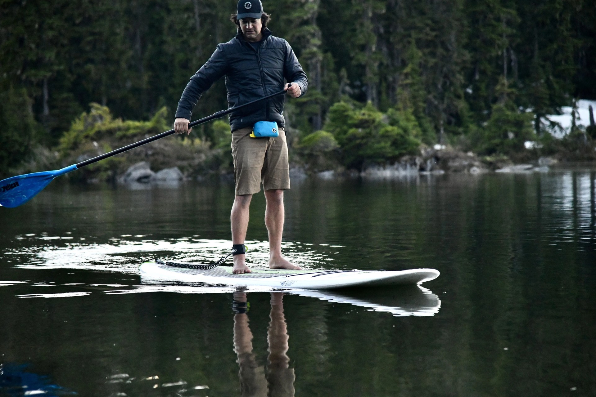 man wearing mustang survival fanny pack while paddle boarding