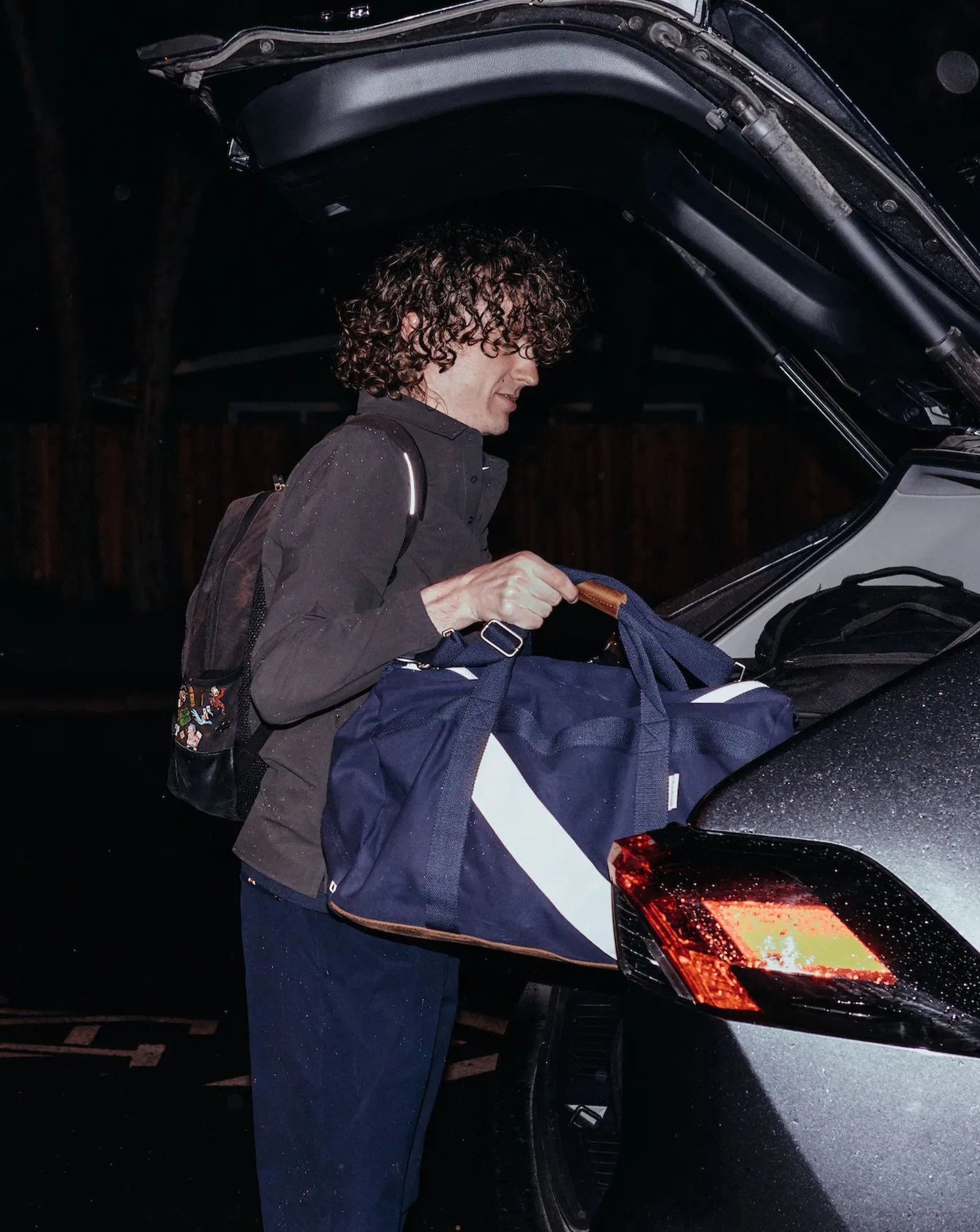 man unloading car wearing tracksmith's rapid transit collection