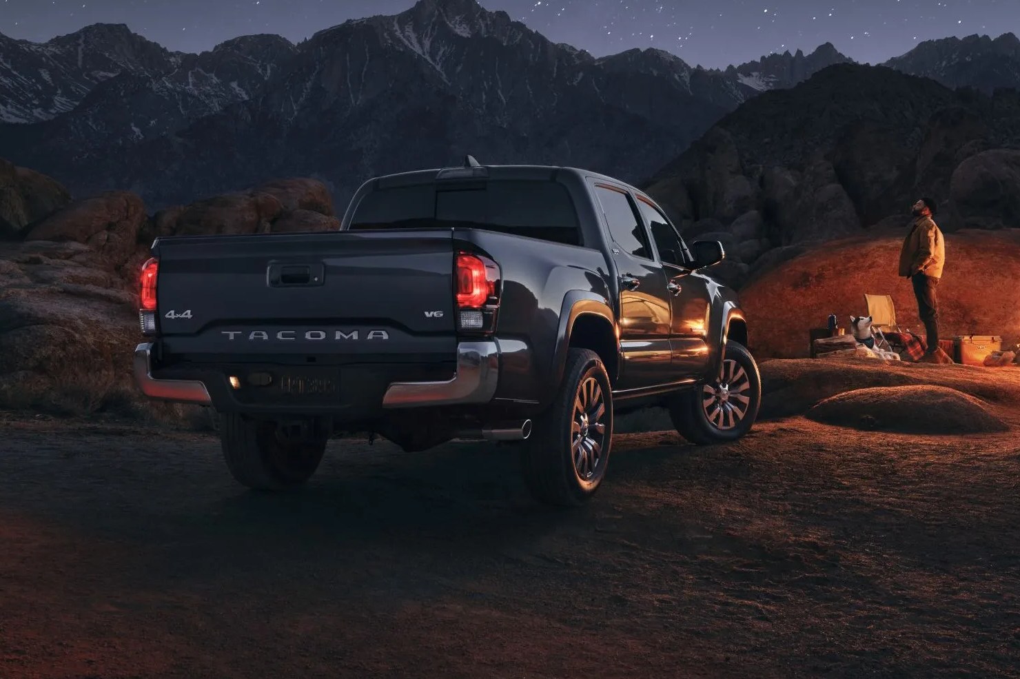 toyota tacoma with new chorme package parked in front of a desert campsite at night