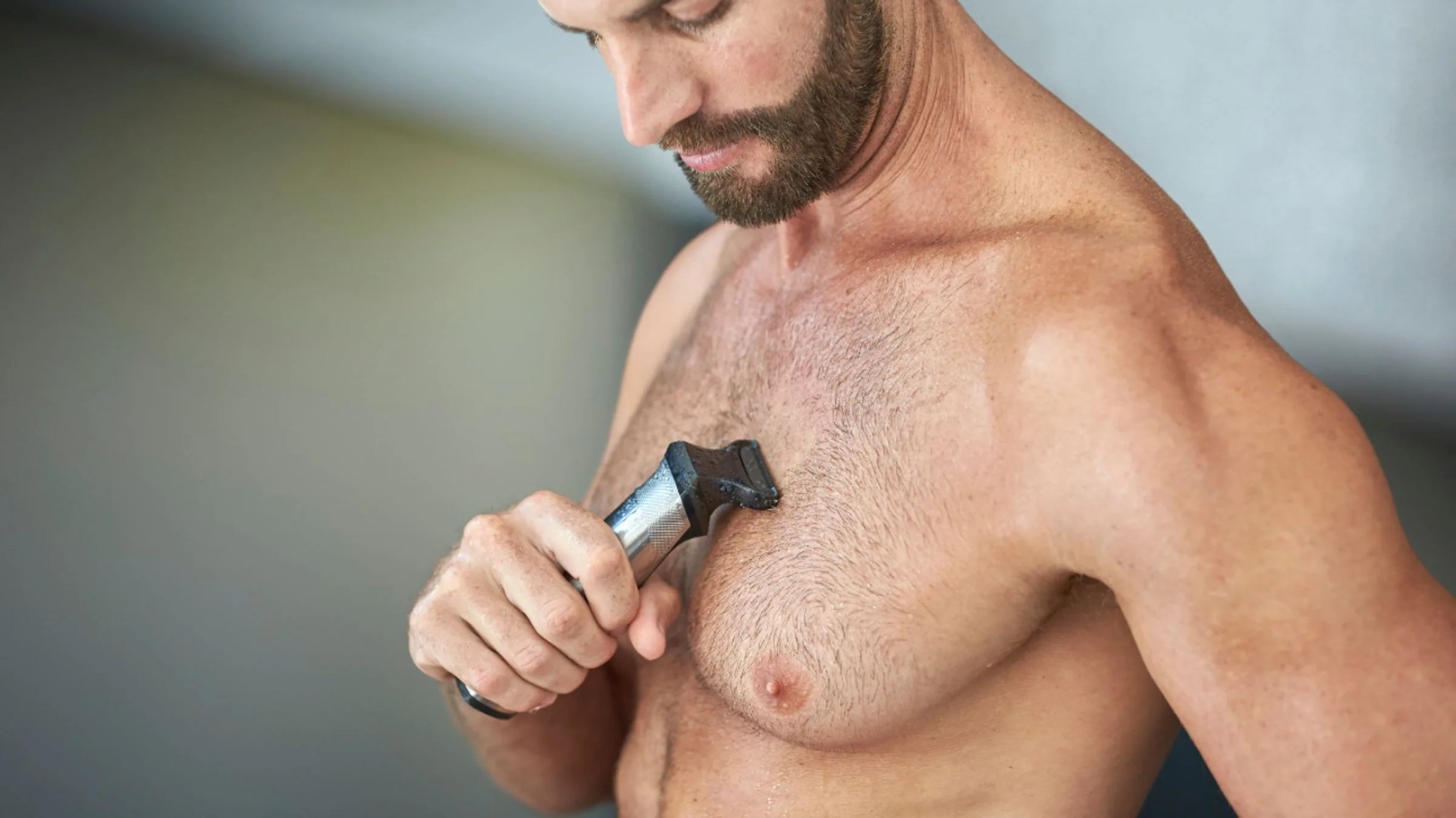 man shaving his chest with philips shaver