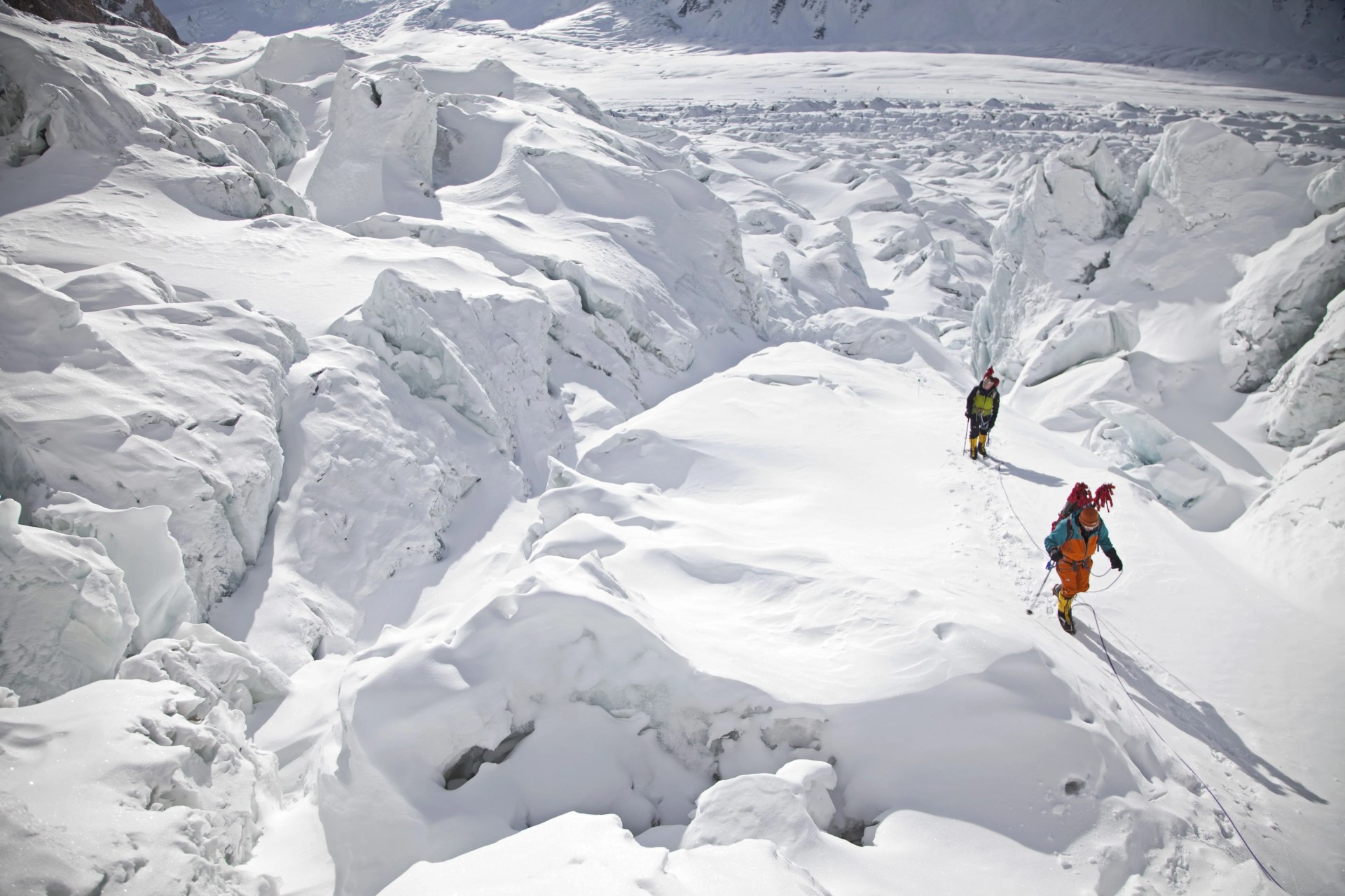 two people trekking across snowy landscape