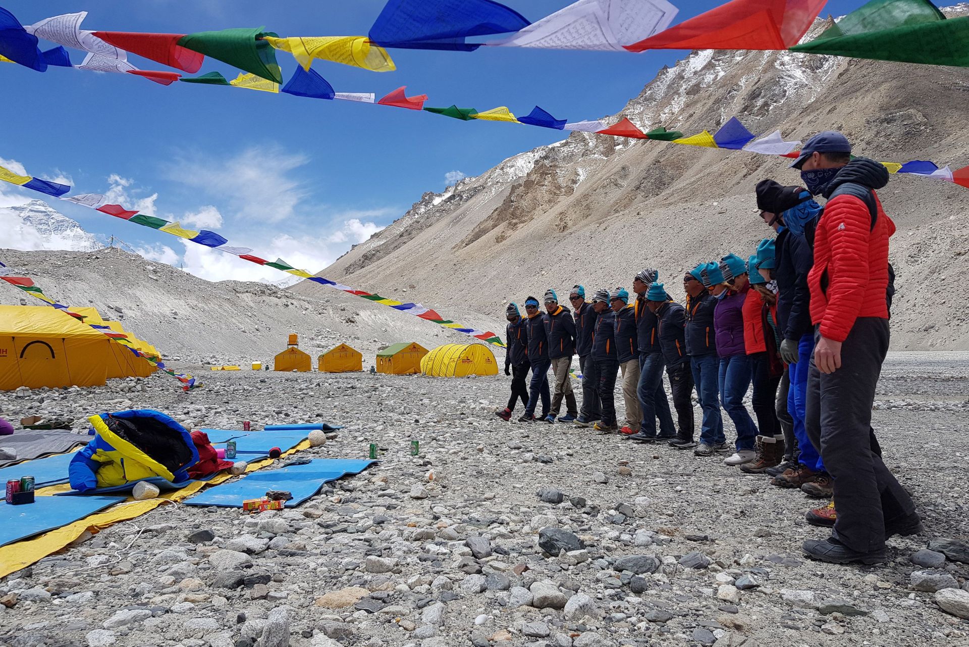 people gathered on mountainside in preparation to climb