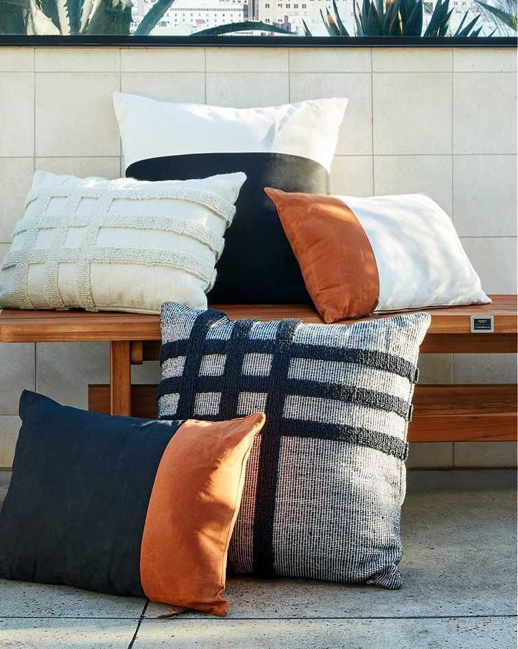 crate and barrel shinola collection of pillows resting on bench