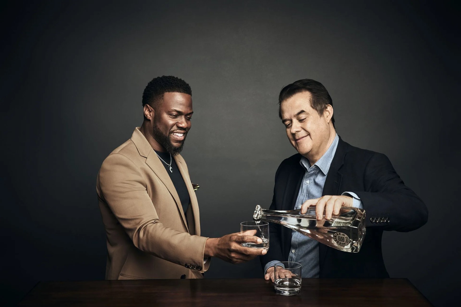 man serves tequila to another man