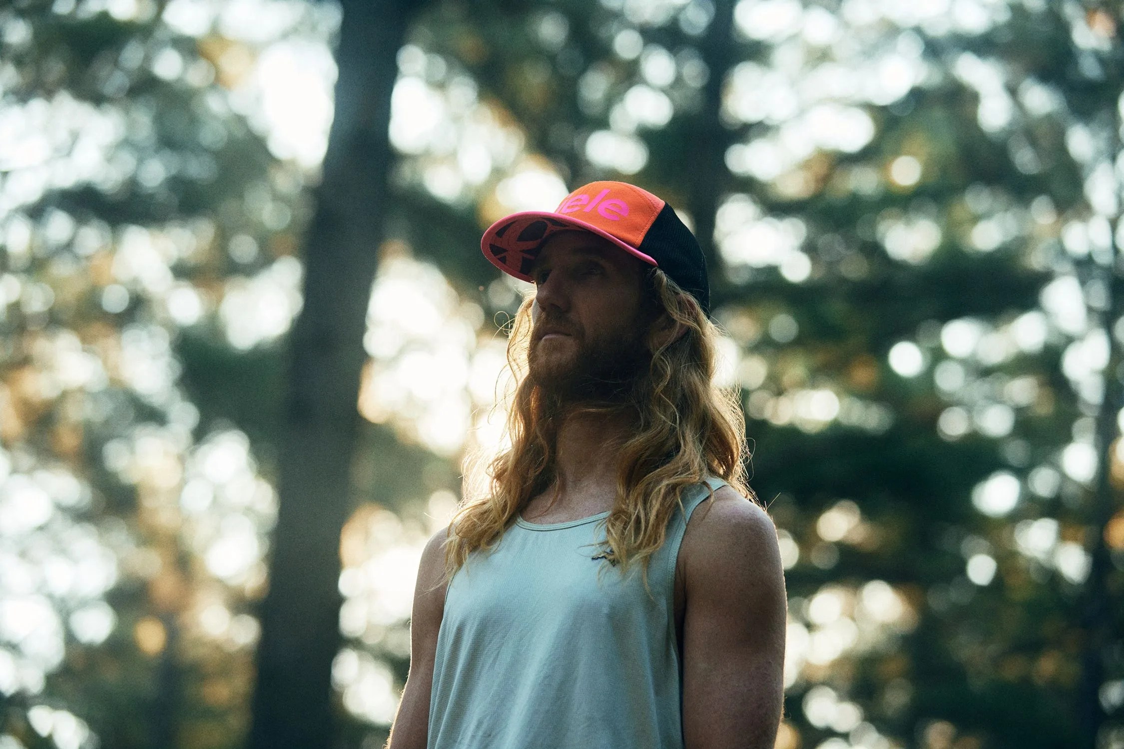 man wearing orange pink and black ciele running cap