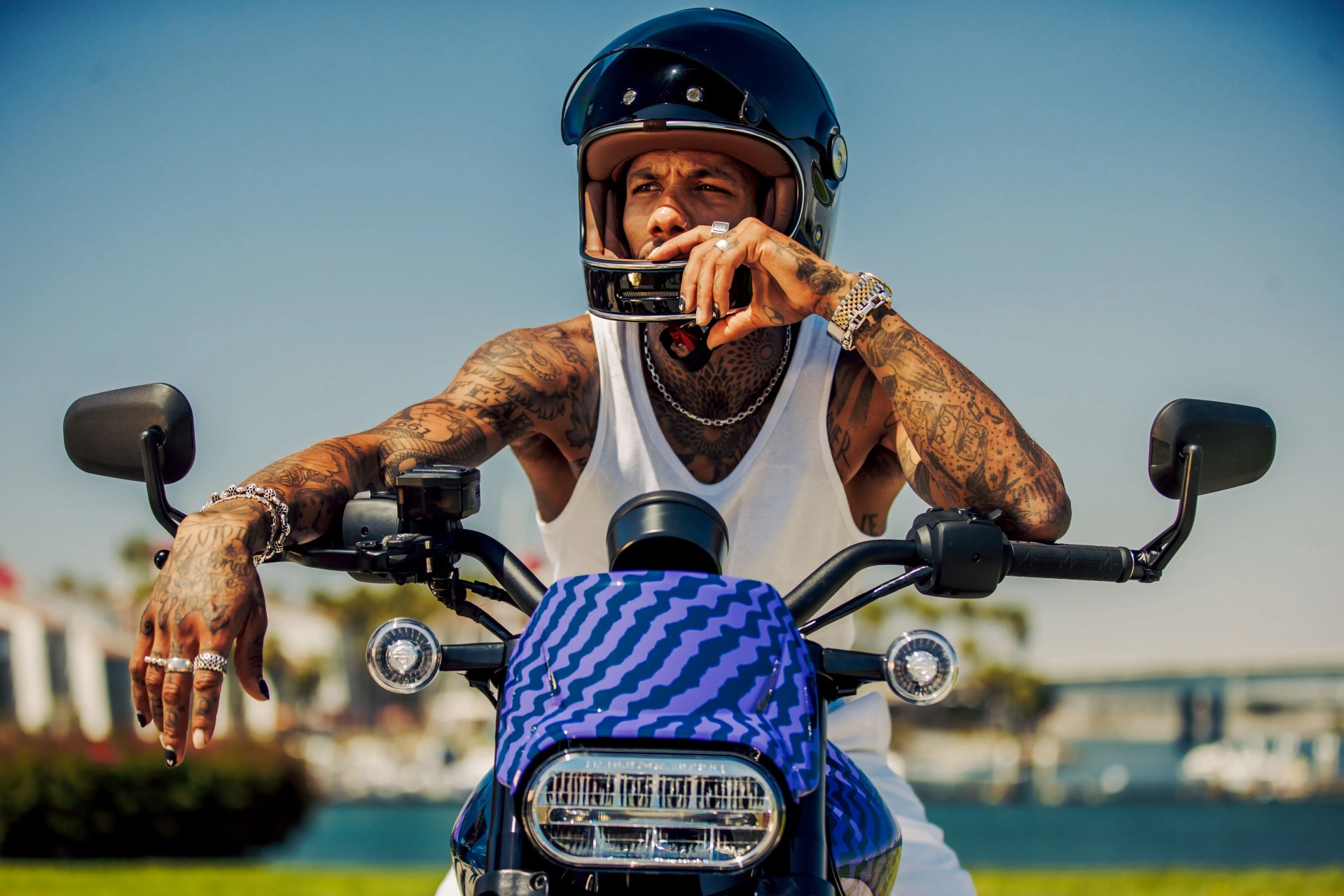 man sitting on livewire s2 del mark electric motorcycle with waterfront in the background
