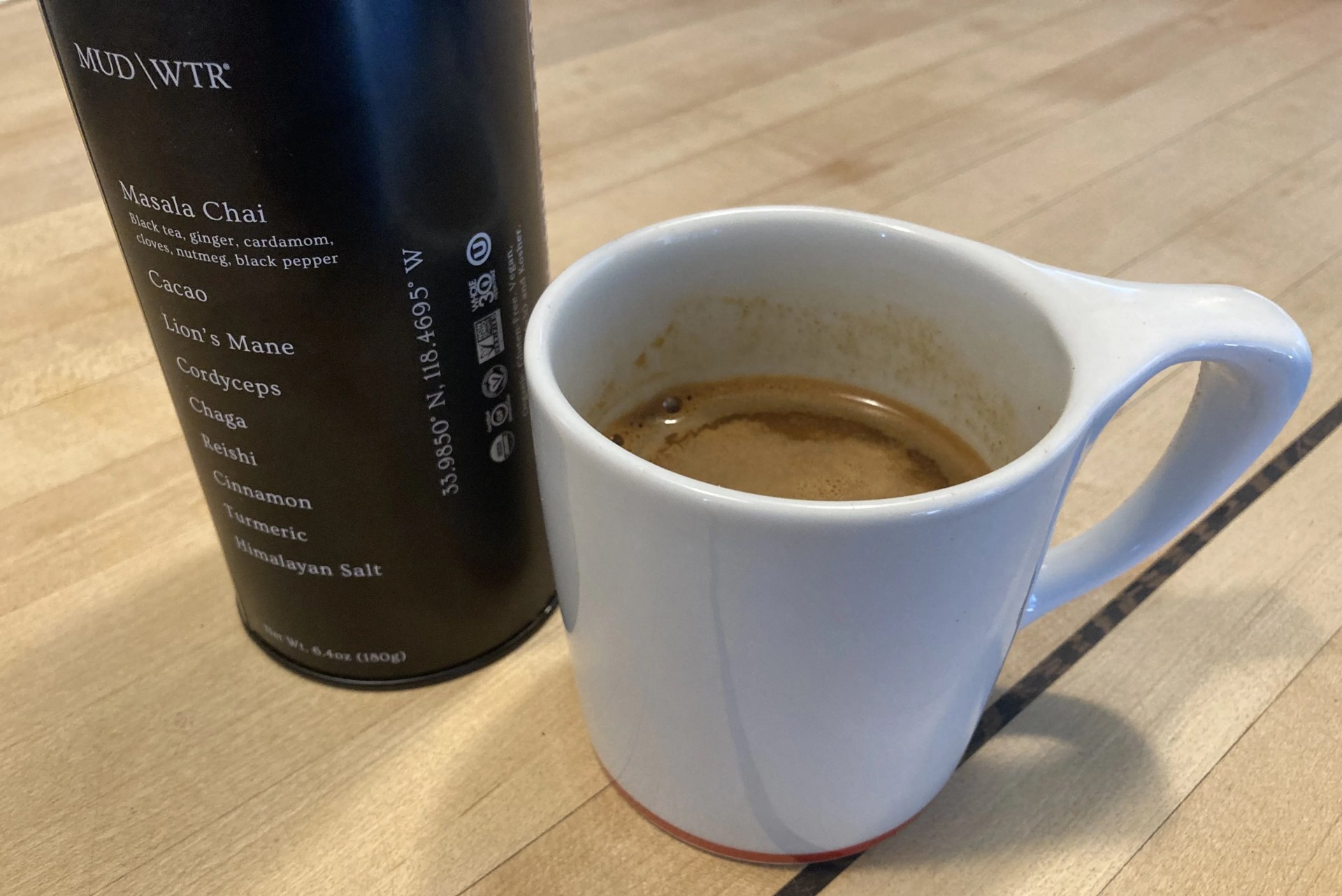 coffee cup next to contain of mushroom coffee