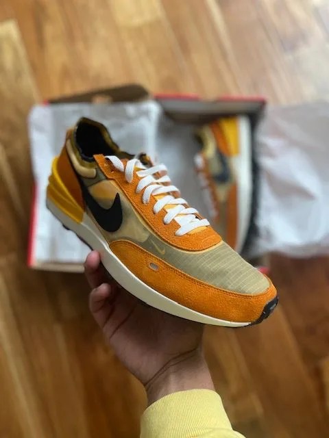 writer holding a nike waffle one sneaker